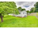 Lush green lawn surrounds the side of the house with its well-kept white siding and mature trees at 814 Grace St, Kings Mountain, NC 28086
