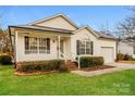 Charming single-story home with white siding, a well-manicured lawn, and an attached single-car garage at 828 Saint Andrews Pl, Concord, NC 28025