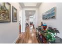 Elegant hallway featuring hardwood floors, decorative artwork, and a view into the home's living spaces at 8516 Profit Ln, Charlotte, NC 28215