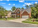 Charming two-story brick home with well-manicured lawn, mature trees and attached two-car garage in desirable neighborhood at 1011 Wadsworth Ln, Indian Trail, NC 28079