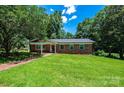 Charming brick home with a manicured lawn, mature trees, and a welcoming front porch at 1036 11Th Street Circle Nw Dr, Hickory, NC 28601