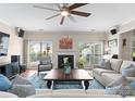 Cozy living room with a fireplace, plush seating, and an abundance of natural light at 112 Steeplechase Ave, Mooresville, NC 28117