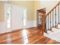Bright foyer featuring hardwood floors, staircase with wood and iron railing and a front door with sidelights at 13037 Angel Oak Dr, Huntersville, NC 28078