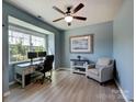 Serene home office space with a large window, modern desk setup, and comfortable seating area at 1324 Mona Vale Dr, Huntersville, NC 28078