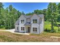Attractive two-story home displaying a well-manicured lawn, mature trees, and a welcoming facade in a peaceful setting at 164 Meadow Glen Dr, Troutman, NC 28166