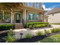 Beautifully landscaped front yard with lush greenery, colorful flowers, and a brick-paved walkway at 1805 Trading Path Ln, Waxhaw, NC 28173
