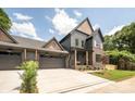 A well-manicured two-story home with a charming gray exterior, brick accents, and a spacious driveway at 1830 Commodore St, Charlotte, NC 28205