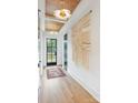 Bright hallway showcasing hardwood floors, stylish light fixtures, and a unique wall hanging at 1830 Commodore St, Charlotte, NC 28205