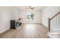 Bright living room featuring hardwood floors, a ceiling fan, and a staircase with white risers and a gray handrail at 212 Mattoon St, Charlotte, NC 28216