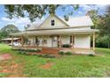 Quaint farmhouse featuring a metal roof and a spacious porch, perfect for enjoying the outdoors at 220 Low Water Bridge Rd, Troy, NC 27371