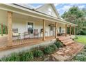 Inviting front porch with classic rocking chairs and wooden support pillars, offering a relaxing outdoor space at 220 Low Water Bridge Rd, Troy, NC 27371