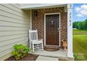 Inviting front entrance with a rocking chair, brown front door, and decorative wreath at 2282 Redstone Dr, York, SC 29745