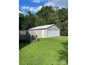 Two-car detached garage near wooden deck stairs, situated on a lush green lawn at 28518 Flint Ridge Rd, Albemarle, NC 28001