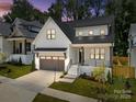 Striking two-story home with a white exterior, grey garage door, and professional landscaping at 3949 Plainview Rd, Charlotte, NC 28208