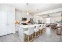Open kitchen features white cabinets, a large island with seating, stainless steel appliances and easy access to the living room at 411 Lahinch Dr, Tega Cay, SC 29708