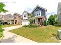 Charming two-story home featuring a manicured lawn, colorful landscaping, and a welcoming front porch at 4268 Coachwhip Ave, Lancaster, SC 29720