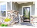 Charming front porch with stone accents, a cozy bench, a decorative sign and colorful flowers at 4268 Coachwhip Ave, Lancaster, SC 29720