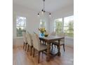 Elegant dining room with large windows, a modern chandelier, and a stylish wooden table with seating at 716 Drakeford Ct, Charlotte, NC 28216