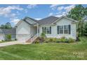 Inviting exterior showing manicured lawn and classic white siding detailing of the home with a two-car garage at 7739 Village Pkwy, Locust, NC 28097