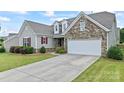 Attractive single-Gathering home with a manicured lawn, stone accents, and attached two-car garage at 9547 Horsebit Ln, Concord, NC 28027