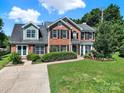 Beautiful two-story home with brick facade, black shutters, and a well-maintained front lawn at 9800 Ashley Farm Dr, Matthews, NC 28105