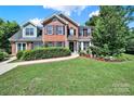 Picture-perfect brick home with a manicured lawn and inviting walkway leading to the front door at 9800 Ashley Farm Dr, Matthews, NC 28105