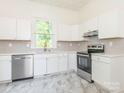 Modern kitchen with stainless steel appliances, white cabinets, and gray subway tile backsplash at 110 College St, Marshville, NC 28103