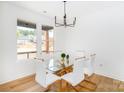Bright dining room featuring hardwood floors, a modern chandelier, and a glass-top table with six chairs at 135 Brookview Dr, Shelby, NC 28152