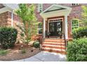 Inviting front entrance with brick steps, black double doors, and manicured landscaping at 13824 Glen Abbey Dr, Charlotte, NC 28278