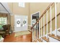 Bright foyer with hardwood floors, a staircase, and double doors with decorative wreaths at 13824 Glen Abbey Dr, Charlotte, NC 28278