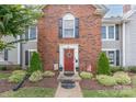Inviting townhouse with a red door flanked by topiaries and well-maintained landscaping at 1735 Robinwood Rd, Gastonia, NC 28054
