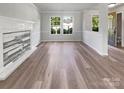 Spacious living room with wood-like flooring, large windows, and an elegant fireplace, ideal for entertaining at 1958 Leesburg Dr, Clover, SC 29710