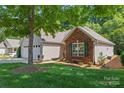 Exterior shows manicured lawn with mature tree providing shade to the house at 210 Oak Village Pkwy, Mooresville, NC 28117