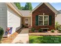 A close-up view of the entrance featuring a brick wall, a welcoming front door and a home sweet home sign at 210 Oak Village Pkwy, Mooresville, NC 28117