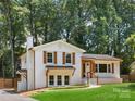 Charming home featuring white brick, wood accents, mature trees, and a well-kept lawn at 2120 Shadyview Dr, Charlotte, NC 28210