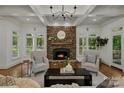 Cozy living room featuring a stone fireplace, hardwood floors and a coffered ceiling at 3408 Sandalwood Ln, Waxhaw, NC 28173
