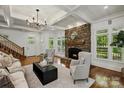 Elegant living room with a stone fireplace, coffered ceiling, and hardwood floors at 3408 Sandalwood Ln, Waxhaw, NC 28173