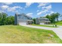 View of two-story homes featuring stone accents, attached two-car garages, and large lawns at 3654 Azalea Ridge Dr, Mount Holly, NC 28102