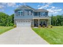 Charming two-story home featuring stone accents, an attached two-car garage, and a manicured lawn at 3654 Azalea Ridge Dr, Mount Holly, NC 28102