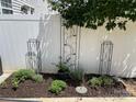 A backyard garden features beautiful plants and decorative metal trellises against a white fence at 4103 Christine Ln # E, Waxhaw, NC 28173
