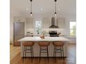 Bright, modern kitchen featuring an island, stainless steel appliances, and stylish pendant lighting at 720 Drakeford Ct, Charlotte, NC 28216