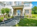 Inviting front porch with stone accents, decorative pillars, and an elegant entrance at 7737 Pleasant Valley Dr, Harrisburg, NC 28075