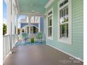 Relaxing covered porch featuring rocking chairs, a ceiling fan, and views of the neighborhood at 8918 Cotton Press Rd, Charlotte, NC 28277