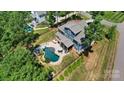 Aerial view showcases a beautiful backyard with a private pool, patio area, and lush landscaping at 101 Cross Current Ln, Belmont, NC 28012