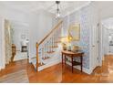 Inviting foyer featuring hardwood floors, wallpaper accents, a wooden staircase, and stylish decor at 1119 Holleybank Dr, Matthews, NC 28105
