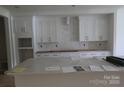 Bright kitchen featuring white cabinets with gold hardware, marble countertops, and herringbone backsplash at 118 Still Creek Dr, Mooresville, NC 28115
