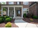 Inviting front porch with stone accents, white pillars, and manicured landscaping at 16016 Reynolds Dr, Fort Mill, SC 29707