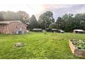 Expansive backyard with mature trees, sheds and a garden area at 169 Smith Clemmer Rd, Mount Holly, NC 28120