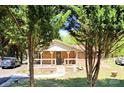 Quaint brick house framed by trees, featuring a welcoming front porch at 169 Smith Clemmer Rd, Mount Holly, NC 28120