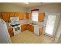 The kitchen features white appliances, an abundance of cabinet space, and direct access to the outdoors at 2150 Winthrop Chase Dr, Charlotte, NC 28212